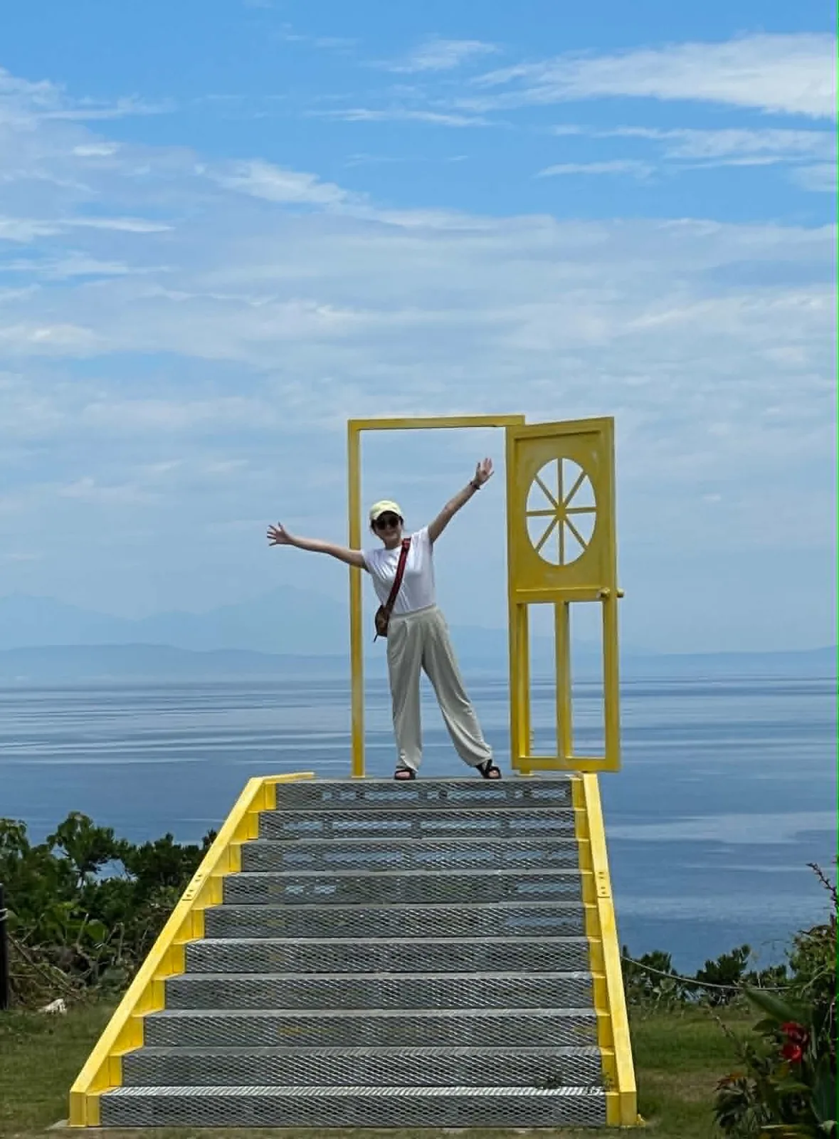 海を望む丘の上で両手を広げる参加者