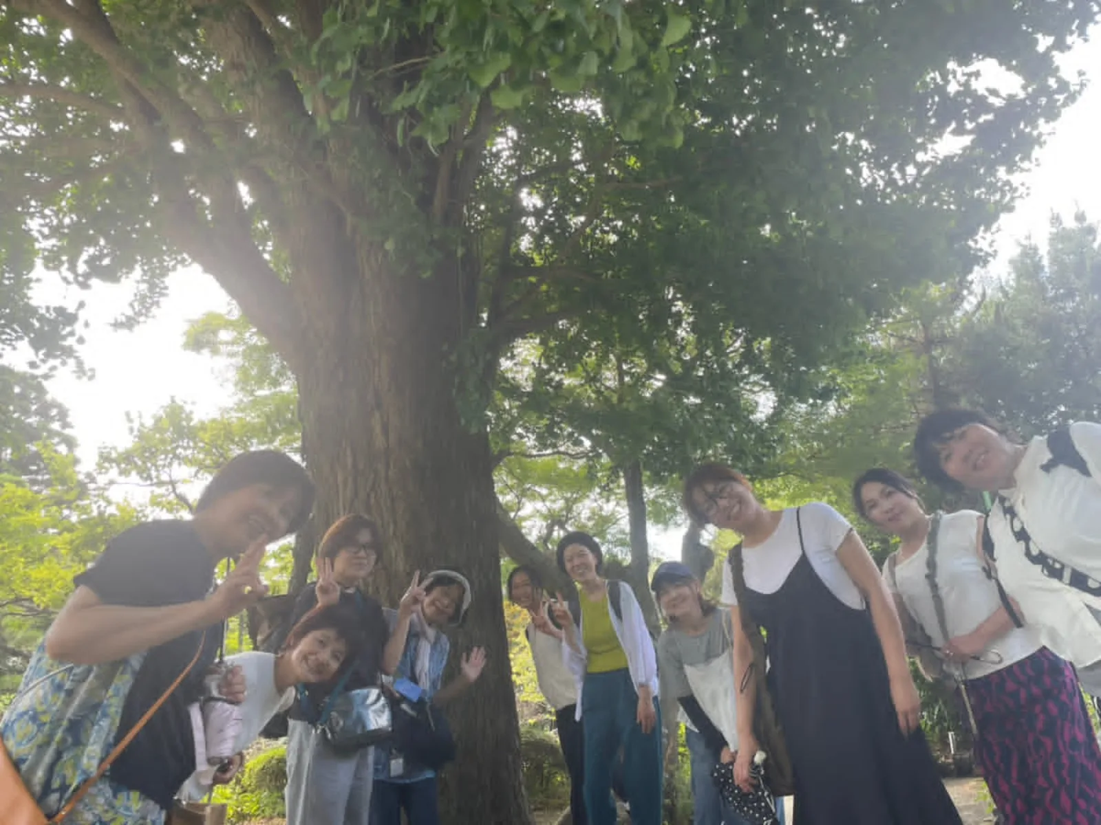 大樹の下で笑顔の参加者集合写真
